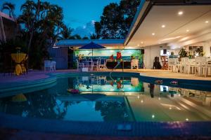 a house with a swimming pool at night at Pirate's Inn in Bridgetown