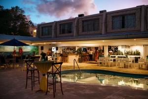 a building with a pool and tables and chairs at Pirate's Inn in Bridgetown