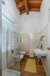een badkamer met een douche, een wastafel en een toilet bij Appartamento Le Vele - BGL in Sirmione