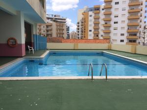 a swimming pool on the roof of a building at Apartamento Cruzeiro Praia da Rocha in Portimão