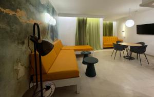 a living room with a yellow bench and a table at Aparthotel Boutique Poniente Playa in San Antonio