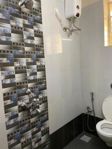 a bathroom with a toilet and a wall ofds at Serenity Casa in Talaulim +4 photos