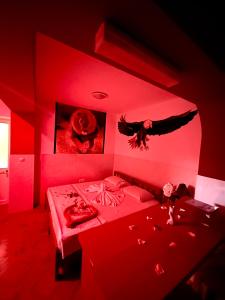 a red room with a bed with an eagle on the wall at Casa BB&Djassi in Ponta do Sol