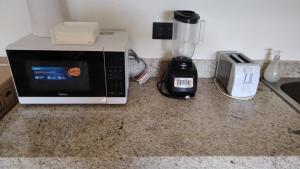 a kitchen counter with a microwave and a blender at Chicxulub hermoso in Chicxulub