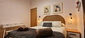 Un dormitorio con una cama con dos zapatos. en DS Puente-Romano Suite, en Córdoba