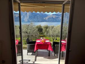 a table and chairs on a balcony with a view of a lake at Villalvento in Brenzone sul Garda