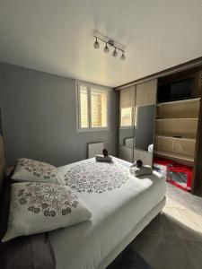 1 dormitorio con cama y espejo en Rez-de-chaussée de plain-pied avec parking privé au centre ville en Dieppe