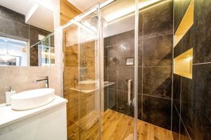 y baño con lavabo y ducha acristalada. en Apartament Kamieniec, en Zakopane