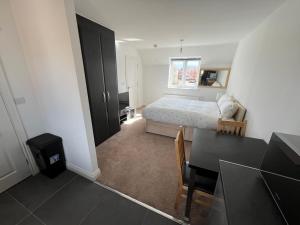 1 dormitorio con cama, mesa y comedor en Apartment suites in Broughton, Milton keynes en Broughton