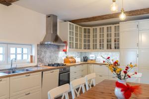 uma cozinha com armários brancos e uma mesa de madeira em Douro Mool Guest House em Lamego
