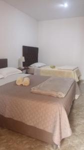 a bedroom with two beds with towels on them at Huacachina Desert House in Ica