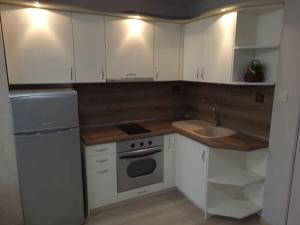 a kitchen with white cabinets and a sink at Lux Apartment Sisi in Burgas City