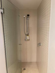 um chuveiro na casa de banho com uma parede em azulejo em Stunning Water View Apartment - Pool, Gym, Sauna. em Cairns