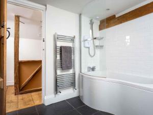 een witte badkamer met een bad en een douche bij Hope Cottage in Moreton in Marsh +24 foto's
