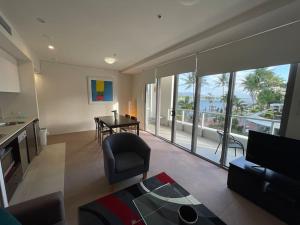 uma sala de estar com um sofá e uma mesa com vista em Stunning Water View Apartment - Pool, Gym, Sauna. em Cairns