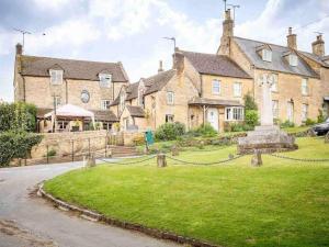 een groot huis met een grasveld ervoor bij Hope Cottage in Moreton in Marsh