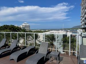 uma varanda com cadeiras e vista para o oceano em Stunning Water View Apartment - Pool, Gym, Sauna. em Cairns