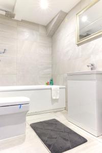 een badkamer met een wit bad en een wastafel bij The Shoreditch Creative Studio in Londen