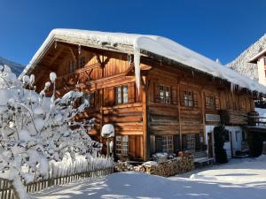 a log cabin in the snow with a fence at Appartement Schankwirtschaft in Pfronten