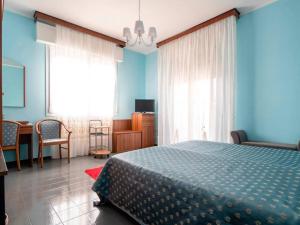 a bedroom with blue walls and a bed and a table at Il Leprotto - Room & Breakfast in Altedo
