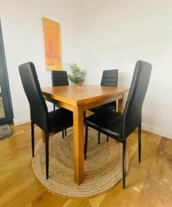 a wooden table with four black chairs around it at Comfy Canal View Apartment in Coventry