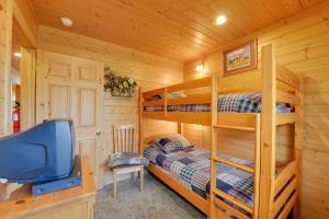 a bedroom with bunk beds and a television in a cabin at Cozy Henrys Lake Escape - 20 Miles to Yellowstone! in Island Park
