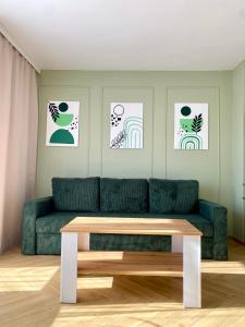 a living room with a green couch and a table at Apartament Zielone Serce Miasta in Mrągowo