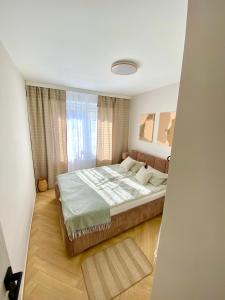 a bedroom with a large bed and a window at Apartament Zielone Serce Miasta in Mrągowo