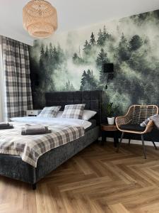a bedroom with a bed and a painting of trees at Apartament Kamienna 28 z prywatną sauną in Wisła