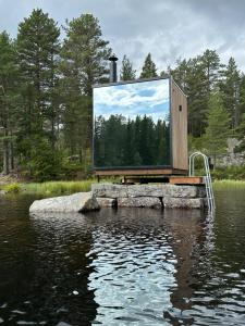 un espejo grande sentado sobre un cuerpo de agua en Spegle Hyllandsfoss, en Åmot