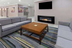 a living room with a couch and a table and a fireplace at Holiday Inn Chicago/Oak Brook, an IHG Hotel in Oakbrook Terrace