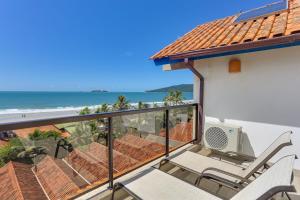 een balkon met stoelen en uitzicht op de oceaan bij Costa Norte Ingleses Hotel in Florianópolis