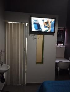 a flat screen tv on the wall of a bedroom at E-JOFF Lodge in Johannesburg
