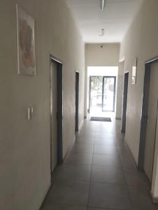 an empty hallway with doors and a tile floor at E-JOFF Lodge in Johannesburg