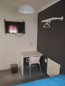 a bedroom with a desk and a bed and a lamp at E-JOFF Lodge in Johannesburg