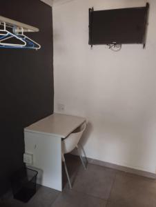 a bathroom with a sink and a tv on a wall at E-JOFF Lodge in Johannesburg