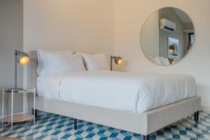 een slaapkamer met een groot wit bed en een spiegel bij Stylish Loft in Santa Ana in Panama-Stad