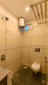 Elle comprend une petite salle de bains pourvue de toilettes et d'une fenêtre. dans l'établissement Hotel Amazing Udaipur (Prime inn ), à Udaipur