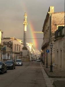 a rainbow in the middle of a city with a statue at La casina di Laura in Maglie