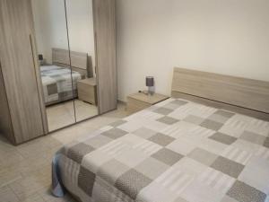 a bedroom with a large bed and a mirror at La casina di Laura in Maglie
