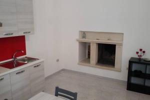 a kitchen with a fireplace in the corner of a room at La casina di Laura in Maglie