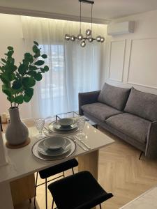 a living room with a table and a couch at Imperial Citi Apartament in Kraków