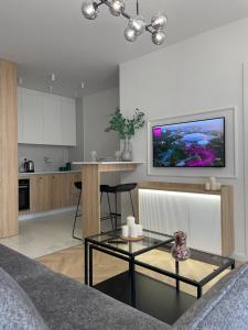 a living room with a table and a kitchen at Imperial Citi Apartament in Krakow