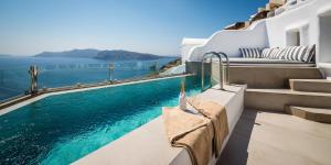 une piscine avec vue sur l'océan depuis une maison dans l'établissement Elite Luxury Suites, à Oia