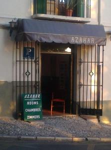 una tienda con un cartel delante de un edificio en casa carmen alhambra, en Granada