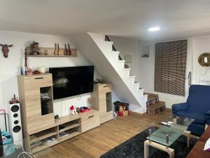 a living room with a tv and a staircase at Choza Azahares in Santiponce