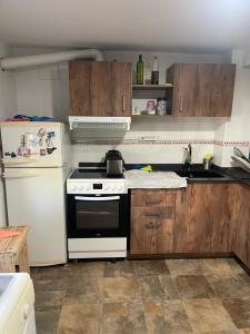 a kitchen with a white stove and a white refrigerator at Choza Azahares in Santiponce