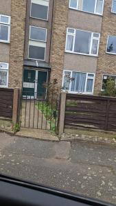 a fence in front of a brick building at Beautiful and peaceful large double bedroom near Olympic Park in Stratford London in London