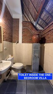 a bathroom with a toilet and a sink at Villa Lombok Senggigi Kamila Forest By Villaloka in Mangsit