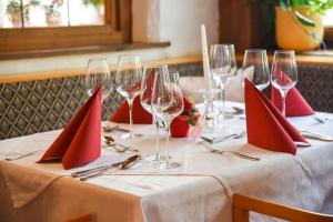 a table with red napkins and wine glasses on it at Gasthof Ramona in Scharnitz